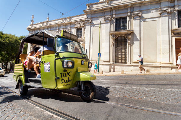 Lisbon, Portugal - Circa 2016 : A Tuk Tuk driving along a street in Lisbon, Portugal. Tuk Tuk's are a great way for tourists to see the city