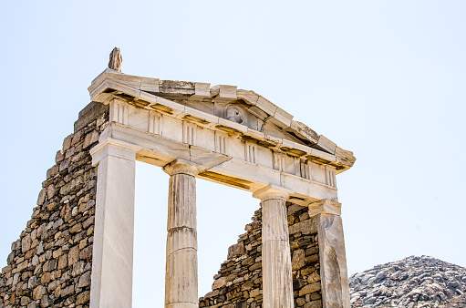 ruins of classical greek architecture carved in marble on the island of delos near mykonos in greece