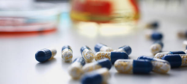 白の上に配置された赤と青の丸薬の山 - vial capsule pill nobody ストックフォトと画像