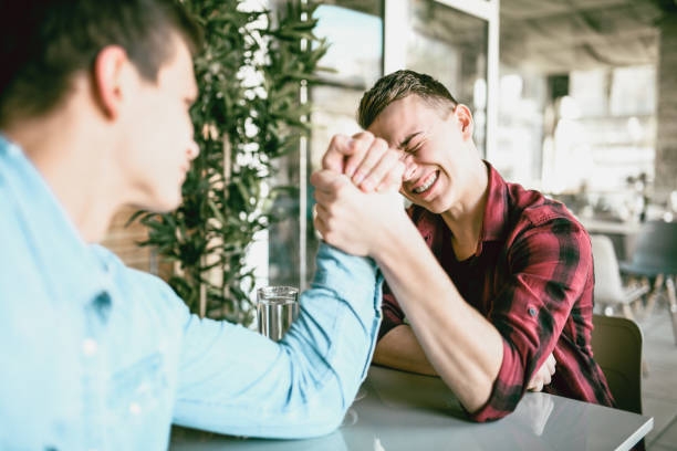 istock Friends Putting Effort Into Arm Wrestling Contest 1140602682