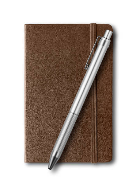 istock Dark Leather closed notebook and pen isolated on white 1140606652
