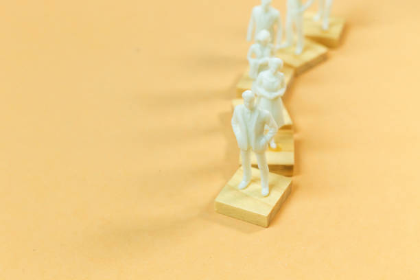istock white  figure miniature on orange pastel for business content. 1140608171
