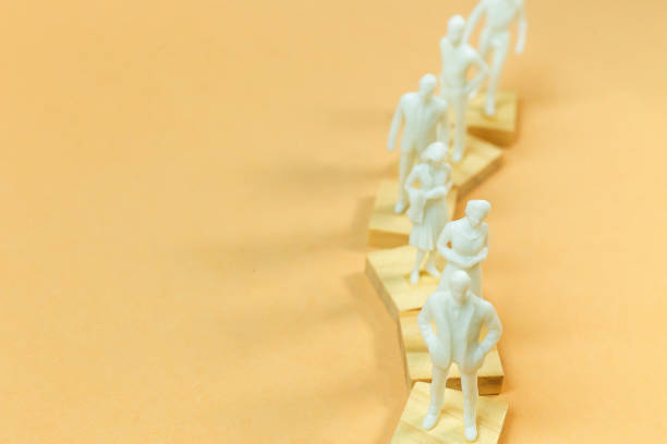 istock white  figure miniature on orange pastel for business content. 1140608229