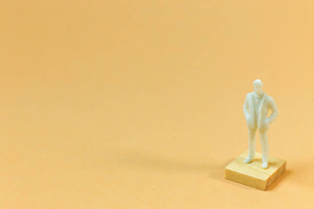 istock white  figure miniature on orange pastel for business content. 1140608266