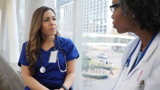 due dottoresse hanno una conversazione seria - serious nurse doctor ethnic foto e immagini stock