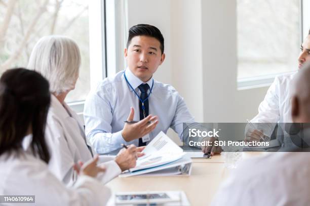 Serious Hospital Executive Talks During Meeting Stock Photo - Download Image Now - Healthcare And Medicine, Business, Hospital