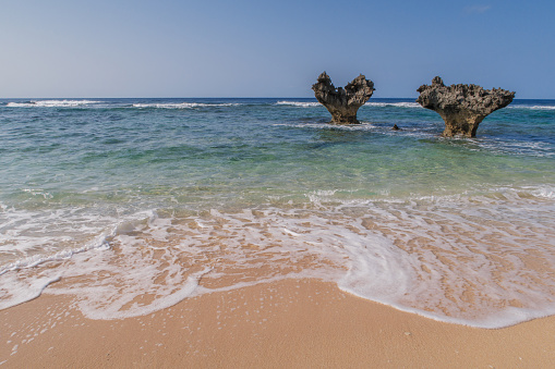 The heart-shaped rocks formed through erosion are a popular attraction on Kouri Island. These rocks are set in the emerald colored sea on the South China Sea.