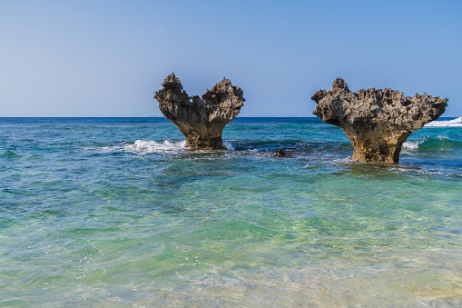 The heart-shaped rocks formed through erosion are a popular attraction on Kouri Island. These rocks are set in the emerald colored sea on the South China Sea.