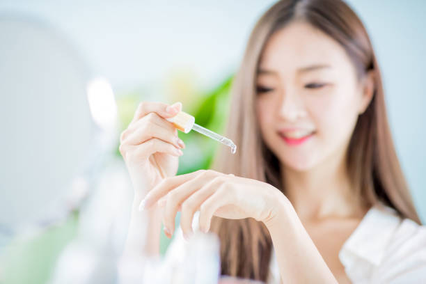 woman dropping collagen moisturizer stock photo