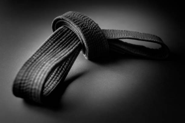 黒の柔道, 合気道, または空手のベルト, 結び目に縛ら, 黒の背景に孤立 - karate judo belt aikido ストックフォトと画像