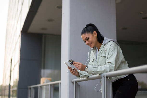 istock Young woman holding credit card and using mobile phone 1140623413