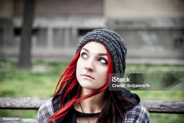 Homeless Girl Young Beautiful Red Hair Girl Sitting Alone Outdoors With Hat And Shirt Feeling Anxious And Depressed After She Became A Homeless Person Close Up Portrait Stock Photo - Download Image Now