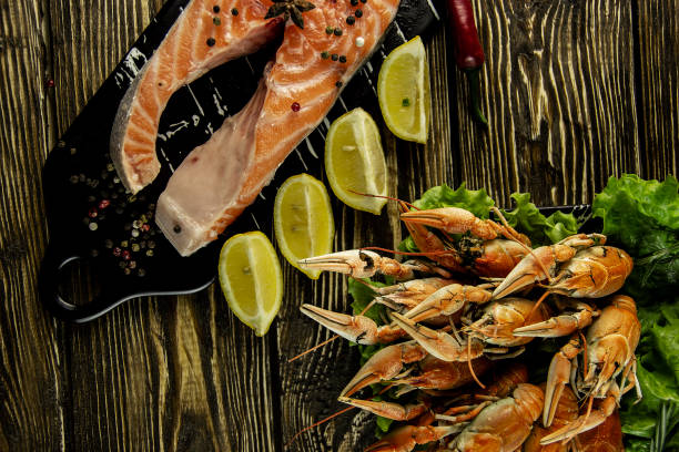 istock Boiled crayfish and salmon on a rough wooden background 1140637577