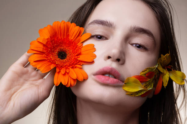 istock Model with no makeup posing with flower petals on face 1140638297
