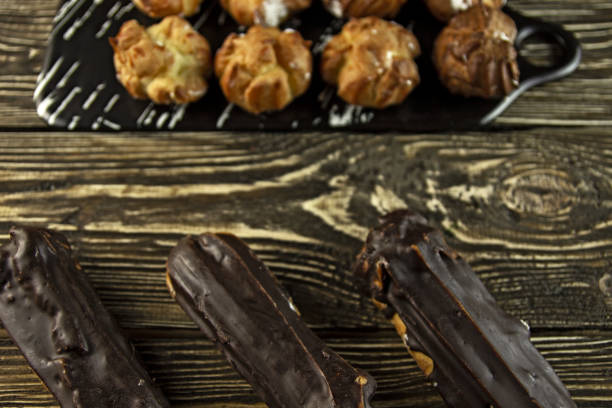 istock cream eclairs on wooden background 1140639180