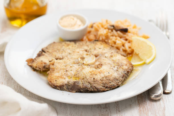 istock fried fish with rice and lemon on white plate 1140639403