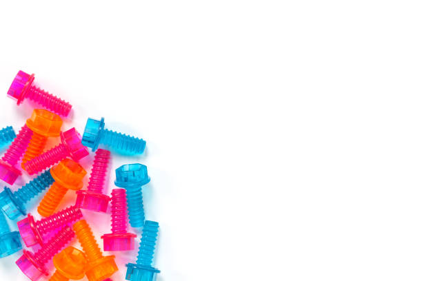 Plastic screws of different colors are arranged in a row on a white background. Children's toys for the development of fine motor skills and thinking. The concept of construction and connection.