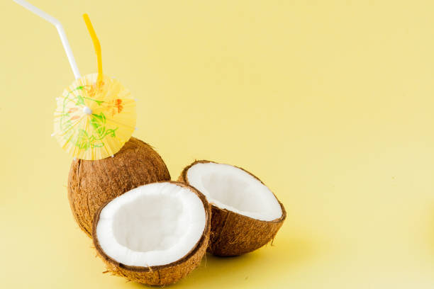 istock Fresh Coconut cocktail with a straws on yellow background, copy space 1140642988