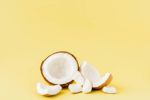 istock close up fresh coconut pieces isolated on a yellow background, tropical fruit concept, flat lay, pop art, copy space 1140643054