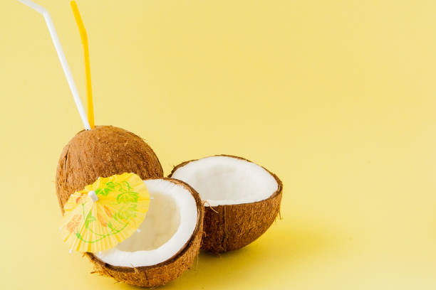 istock Fresh Coconut cocktail with a straws on yellow background, copy space 1140643085