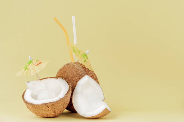 istock Fresh Coconut cocktail with a straws on yellow background, copy space 1140643094