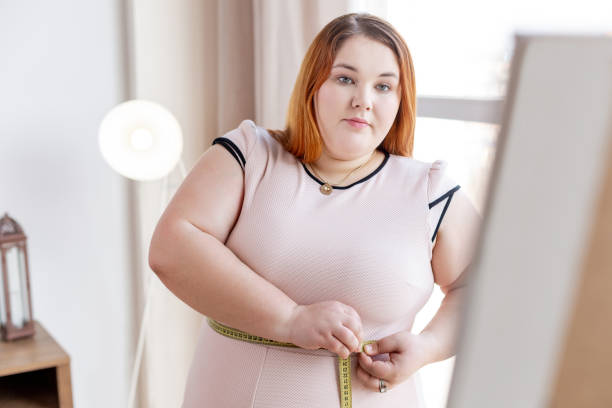istock Serious plump woman thinking about her weight 1140647293