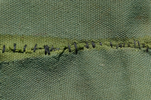 green background of fabric with black stitching on the fabric