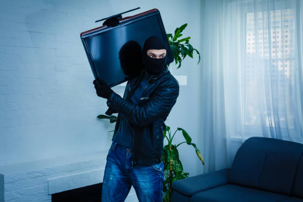 uomo ladro ruba tv set da casa - burglary burglar thief house foto e immagini stock