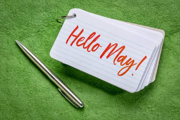 Hello May  - handwriting on an index card with a pen against green textured paper
