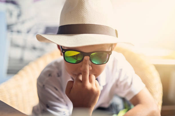 Little boy aged 9 making obscene middle finger gesture at the camera