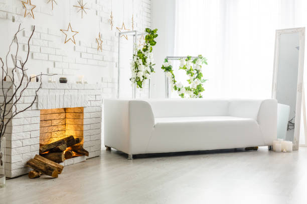 white fireplace in light room with christmas decoration - vehicle interior green sofa indoors imagens e fotografias de stock