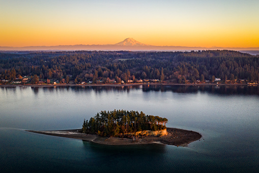 An aerial view of Cutts Island with Mt Rainier in the background at golden hour Puget Sound Washington