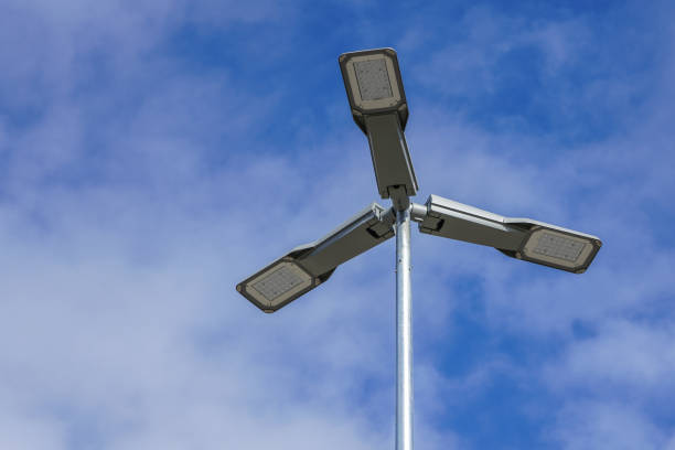istock Three LED street lamps affixed to an iron post against a deep blue sky 1140656039