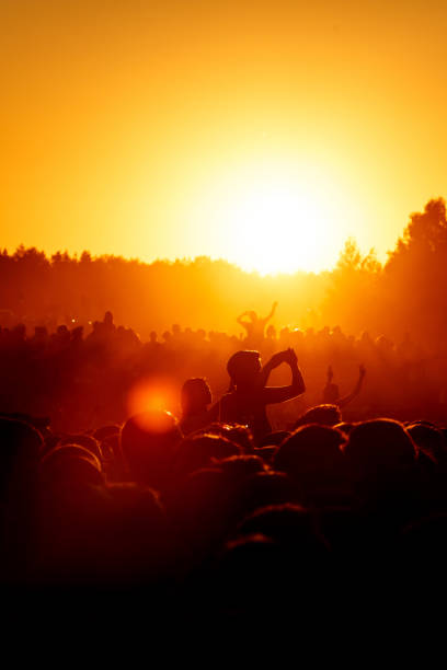 istock Crowd dancing on the summer party. Low sun orange light. 1140657768