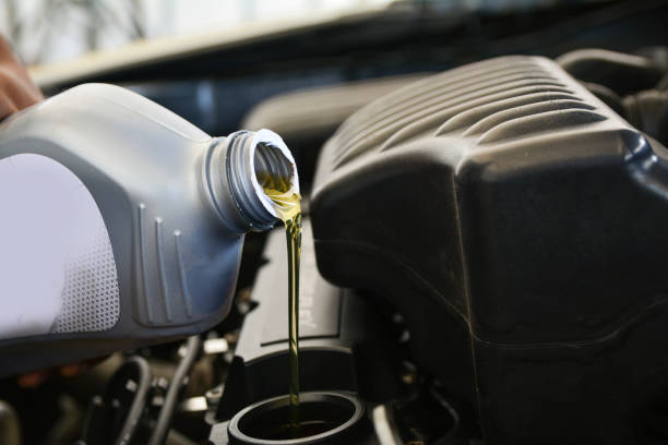 pouring oil into the car engine, refueling - motor oil bottle imagens e fotografias de stock