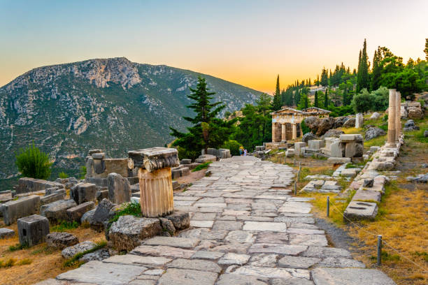 Sunset view of Athenian treasury at the ancient delphi site in Greece Sunset view of Athenian treasury at the ancient delphi site in Greece oracle building stock pictures, royalty-free photos & images