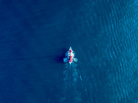 a lone yacht swim in deep blue ocean top view