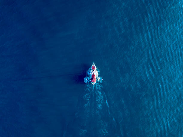 samotny jacht pływać w ciemnoniebieskim widoku z góry oceanu - on top of zdjęcia i obrazy z banku zdjęć