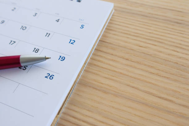 istock calendar page on wood table background with pen point at 19th date 1140682873