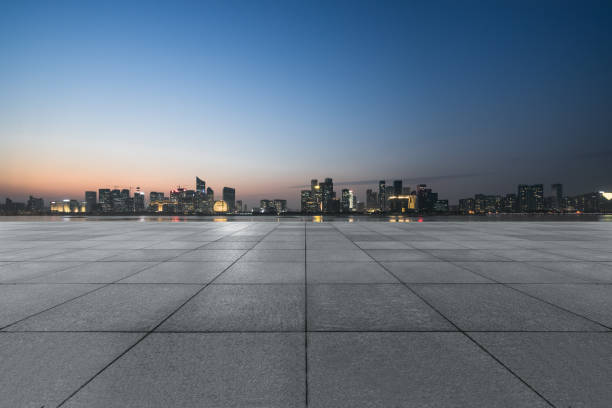 vista nocturna del piso de ladrillo vacío frente al edificio moderno - green city futuristic clean fotografías e imágenes de stock