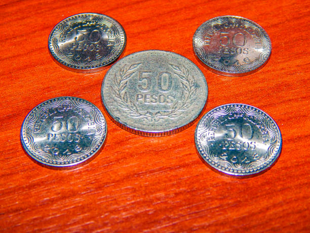 istock Five colombian coins over a wooden brown surface 1140694856