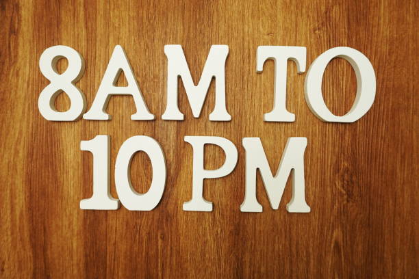 istock 8 AM to 10 PM on wooden background 1140703009