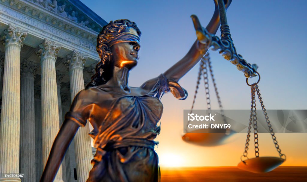 Statue Of Lady Justice And Supreme Court Building A statue of the blindfolded lady justice in front of the United States Supreme Court building as the sun rises in the distance symbolizing the dawning of a new era. Lady Justice Stock Photo