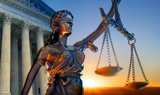 Statue Of Lady Justice And Supreme Court Building A statue of the blindfolded lady justice in front of the United States Supreme Court building as the sun rises in the distance symbolizing the dawning of a new era. statue stock pictures, royalty-free photos & images