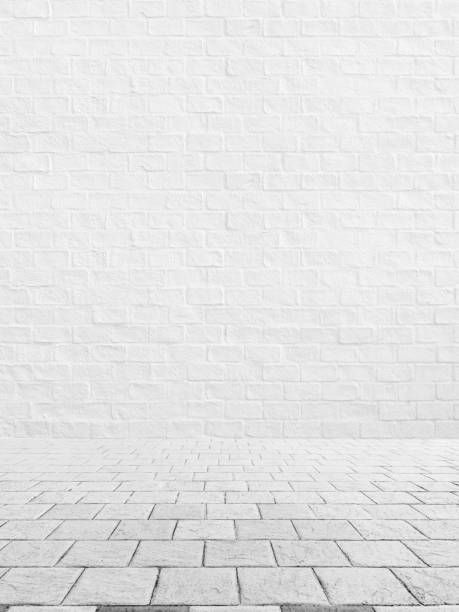 istock Outdoor stone block tile floor texture with white brick wall background. 1140709088