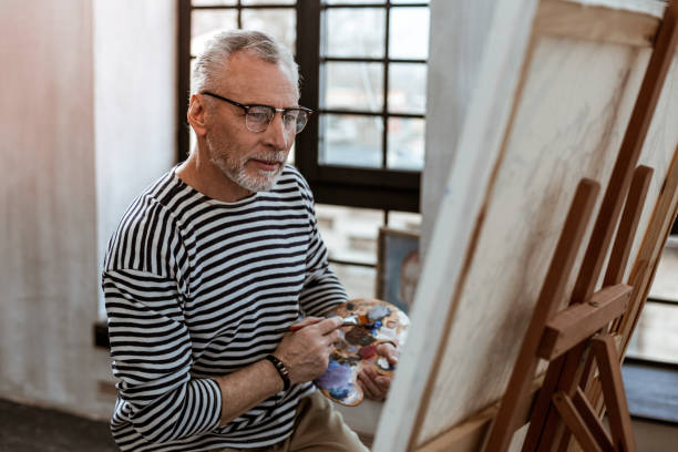 istock Artist mixing some watercolor while painting on canvas 1140711130
