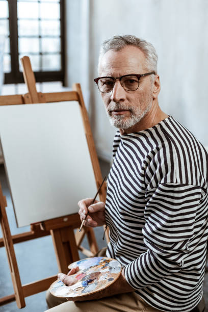 istock Professional artist using gouache while painting on big canvas 1140711152