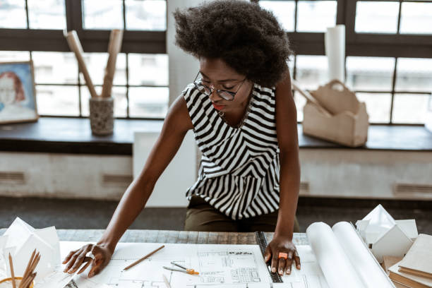 Stylish interior designer wearing rings working on sketches