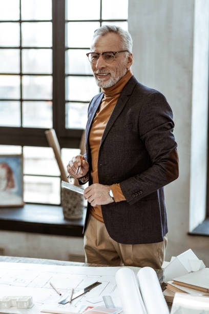 istock Stylish interior designer holding compasses and ruler in his hands 1140713567