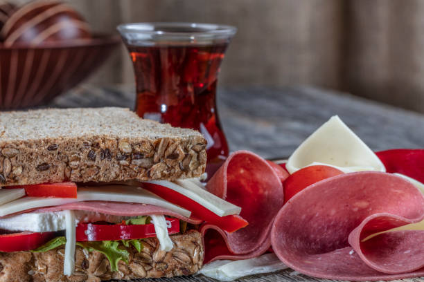 istock Fresh sandwich with salami, tomatoes, lettuce, cheddar cheese and turkish tea. 1140718803